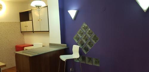 a room with a purple wall with a counter and a chair at Guesthouse Mare&Monti Castelforte in Castelforte