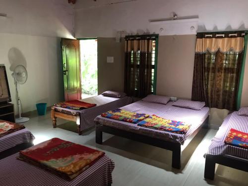 pokój z 3 łóżkami w pokoju w obiekcie Silver Shadow Homestay w mieście Chikmagalur