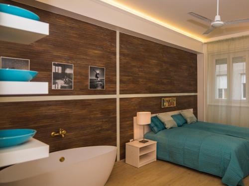 Liszt Studio Holiday Home في بودابست: غرفة نوم مع سرير وحوض استحمام