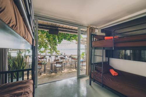 a room with bunk beds and a balcony with a table at Chill Inn Lamai Hostel & Beach Cafe in Koh Samui 