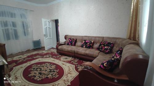 a living room with a couch and a rug at Umid Hostel in Bukhara