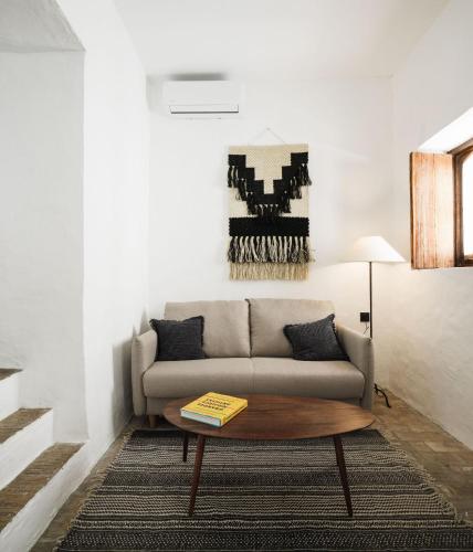 a living room with a couch and a coffee table at Casablanca Vejer Baño Termal in Vejer de la Frontera