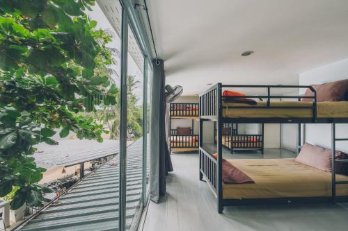 a room with two bunk beds and a balcony at Chill Inn Lamai Hostel & Beach Cafe in Koh Samui 