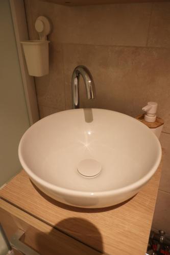 - un lavabo dans la salle de bains avec un bol blanc sur un comptoir dans l'établissement Sweet Riva - duplex chaleureux proche bourg de Ouistreham, à Ouistreham