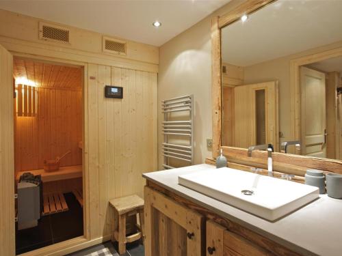 un bagno con lavandino e specchio di Chalet cosy proche des pistes avec sauna et cheminée - Courchevel 1850 - FR-1-564-25 a Courchevel