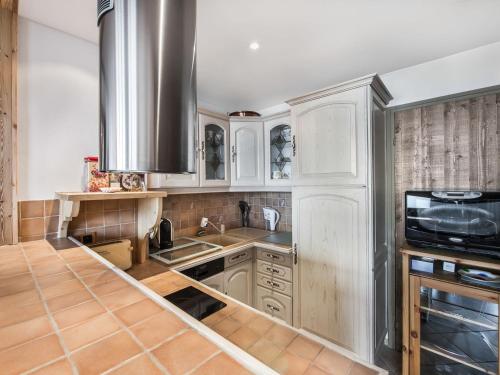 une cuisine avec des armoires blanches et un évier dans l'établissement Appartement Courchevel 1850 avec 2 chambres et services inclus - FR-1-564-37, à Courchevel