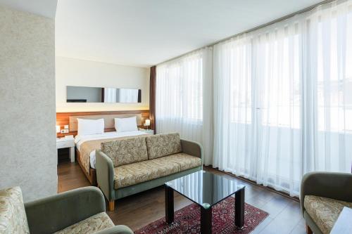 イスタンブールにあるP Galata Hotel - Special Categoryのベッド、ソファ、テーブルが備わるホテルルームです。