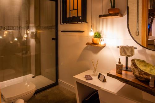 a bathroom with a shower and a toilet and a sink at Loft Industrial 485 na Serra - Bento Gonçalves in Bento Gonçalves