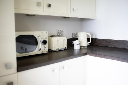 a kitchen counter with a microwave and a toaster oven at Stunning Sea Views, luxury apartment beaches & restaurants are a short walk away in Newquay