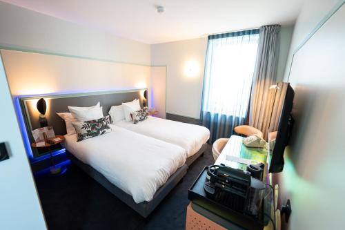 a hotel room with a bed and a window at Aiden by Best Western Clermont-Ferrand Hotel & Spa in Clermont-Ferrand