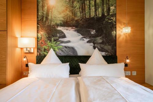 - une chambre avec deux lits et une peinture sur une rivière dans l'établissement Spirit & SPA Birkenhof am Elfenhain, à Grafenwiesen