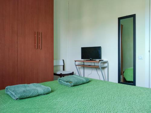 a bedroom with a green bed with two pillows on it at Casa Bignardi - Affitti Brevi Italia in Modena