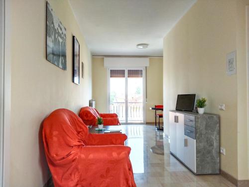 a living room with a red chair and a television at Casa Bignardi - Affitti Brevi Italia in Modena