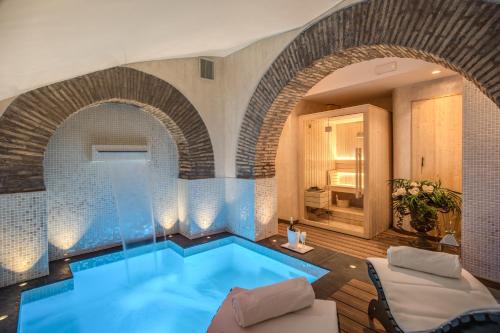 uma piscina num quarto com uma parede de tijolos em Boutique Relais Barozzi & SPA em Roma