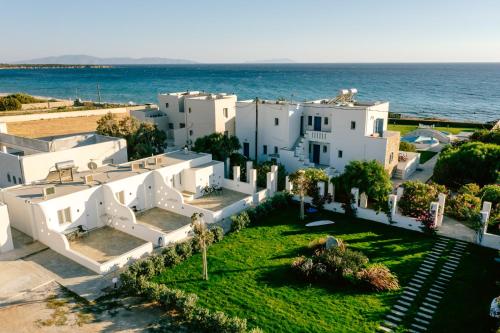 an aerial view of a white house on the beach at Blue Myth Studios in Kastraki