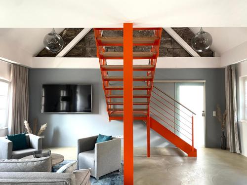 a red staircase in a living room next to a living room at Rotmain Apartments in Bayreuth