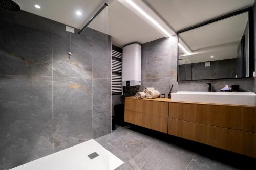a bathroom with a sink and a tub and a mirror at Appartamento Scalinata San Rocco in Limone sul Garda