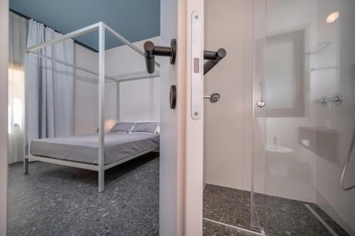a bedroom with a bed and a glass shower at BED 10.5 - DESIGN SUITE in Castellammare del Golfo