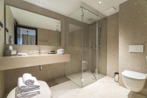 W łazience znajduje się prysznic, toaleta i umywalka. w obiekcie Beach Bay Hvar Hotel w Hvarze