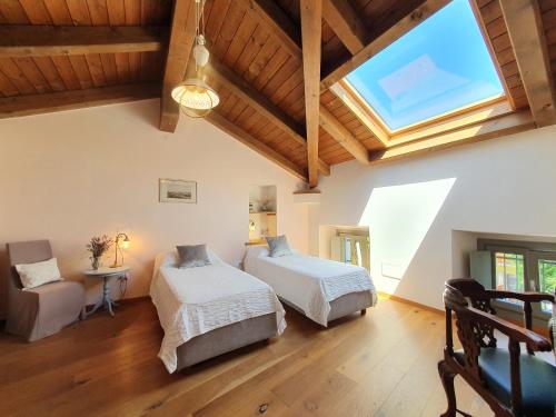 a bedroom with two beds and a large window at Agriturismo Juna in Aurisina