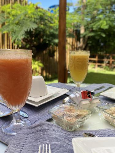 twee glazen drank op een tafel met eten bij Nari Guest Room in Fernando de Noronha