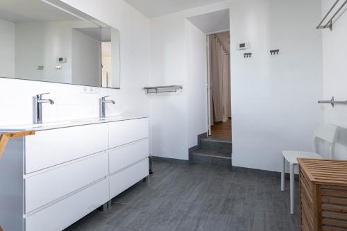 a white bathroom with a sink and a mirror at Belle maison familiale et contemporaine avec piscine in Nantes