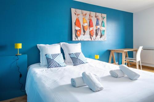 a blue bedroom with a large white bed with pillows at Belle maison familiale et contemporaine avec piscine in Nantes