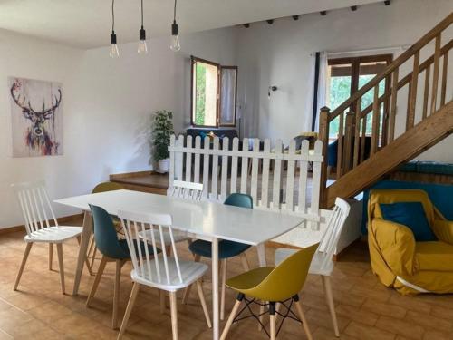 a dining room with a white table and chairs at L'Azilienne, jolie maison à 2 pas du village - L'Azilienne, pretty house 2 steps from village in Le Mas-dʼAzil