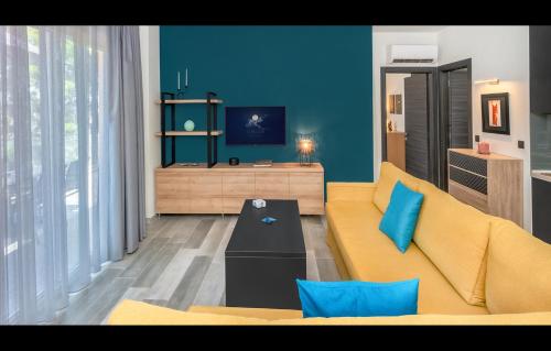 a living room with a yellow couch and a blue wall at LUNAR in Skala Rachoniou