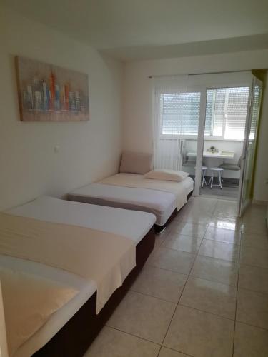 a room with two beds and a table with a table at Mihaela studio apartmans 150m near the beach in Kaštela