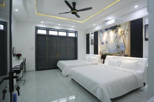 a bedroom with two beds and a ceiling fan at CHIENHOA HOMESTAY in Danang