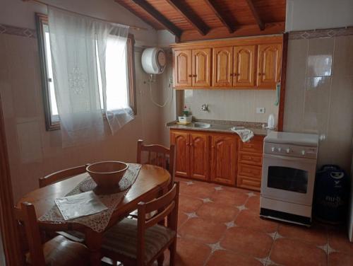 eine Küche mit einem Tisch und Stühlen sowie einem Fenster in der Unterkunft El Sabinar in Vallehermoso