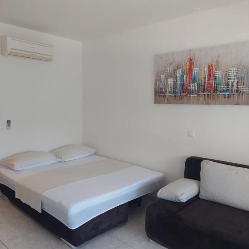 a bed and a couch in a room at Mihaela studio apartmans 150m near the beach in Kaštela