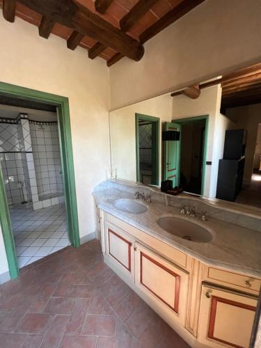 baño con 2 lavabos y espejo grande en Villa Elena, en Orentano