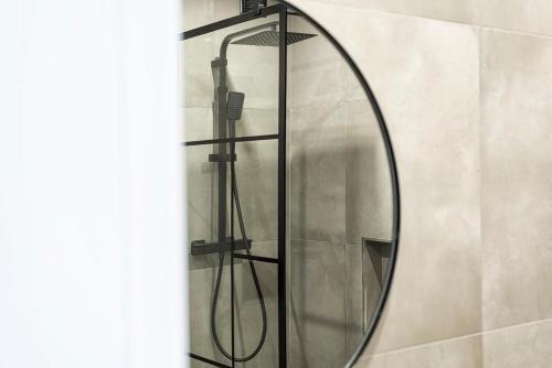 a round mirror in a bathroom with a shower at Estúdios Marina in Vilamoura