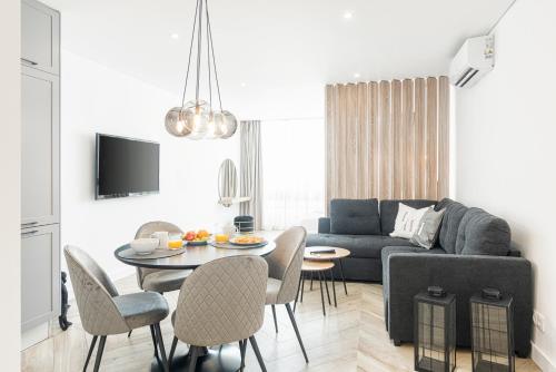 a living room with a couch and a table and chairs at Estúdios Marina in Vilamoura