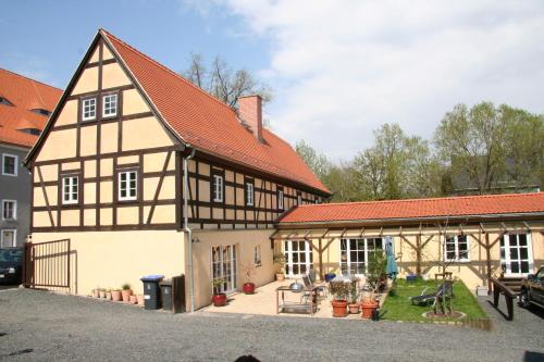 ein altes Gebäude mit einem Innenhof vor einem Haus in der Unterkunft Fachwerkhaus Maxen in Müglitztal