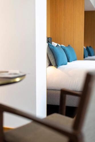 a bedroom with a bed with blue pillows at Howard sur Seine - Asnieres Paris La Defense in Asnières-sur-Seine
