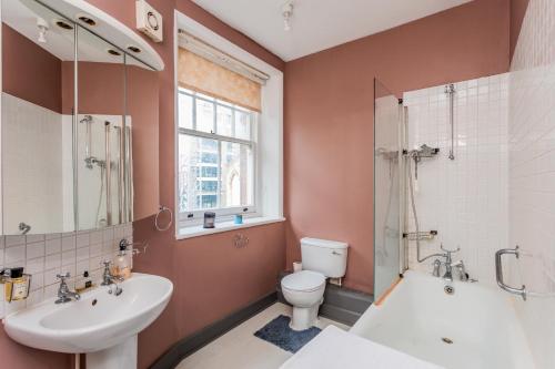 a bathroom with a sink and a toilet and a shower at Unique Character Filled, East London Flat in London