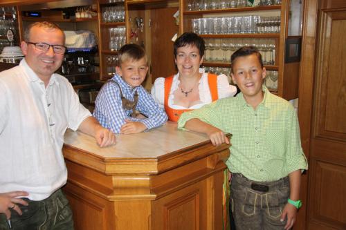 a family standing at a counter in a bar at Gasthof zur Kirche in Kottes