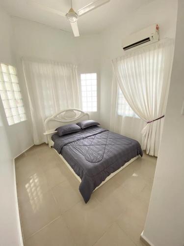 1 dormitorio con 1 cama y 2 ventanas en Chloe's Homestay, en Kuala Terengganu