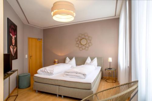 1 dormitorio con 1 cama con sábanas y almohadas blancas en Gasthaus Adler Ettenheim- mit self Check-In - Key Boxes, en Ettenheim