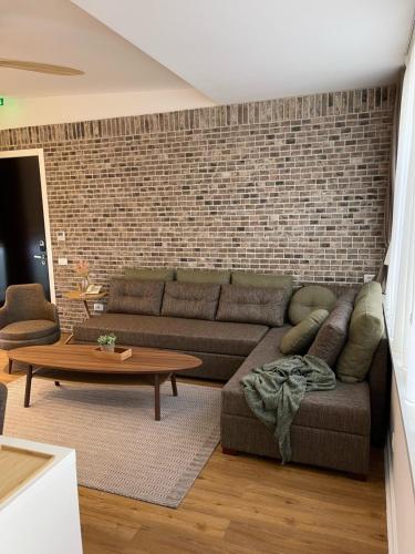uma sala de estar com um sofá e uma parede de tijolos em Belgrade Inn Garni Hotel em Belgrado
