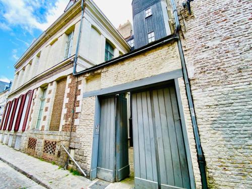 an old brick building with a door on a street at Vieux-Lille : Appartement de charme in Lille