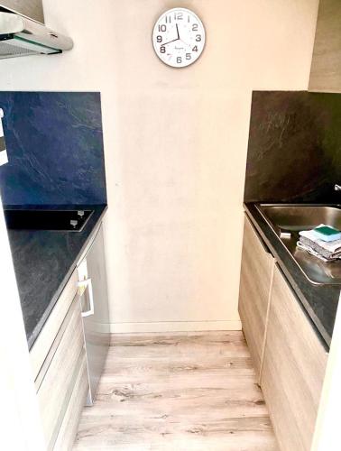 une cuisine avec une horloge murale dans l'établissement Vieux-Lille : Appartement de charme, à Lille