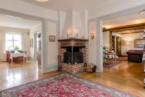 a living room with a brick fireplace and a table at Munkedals Herrgård in Munkedal