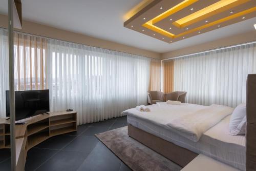 a bedroom with a bed and a flat screen tv at Hotel & Resort Bon Bon in Skopje