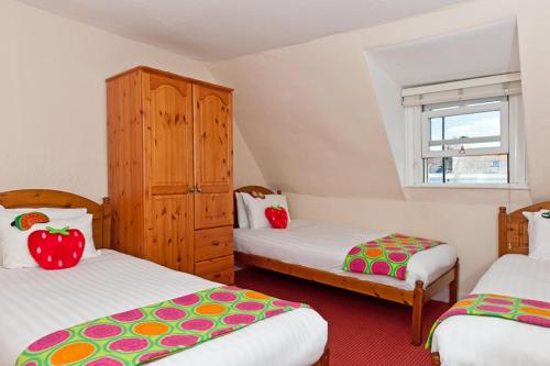a bedroom with two beds and a cabinet with apples on it at Strawberry Fields in Brighton & Hove