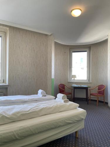 a hotel room with two beds and a table and chairs at Hotel Tabor Rooms in Vienna