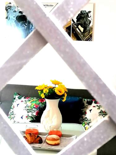 a white vase with flowers on a table with some snacks at Historic Centre - Apartment Near Teatro Massimo in Palermo